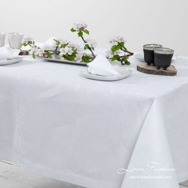 White linen tablecloth with flower ornaments, folded border