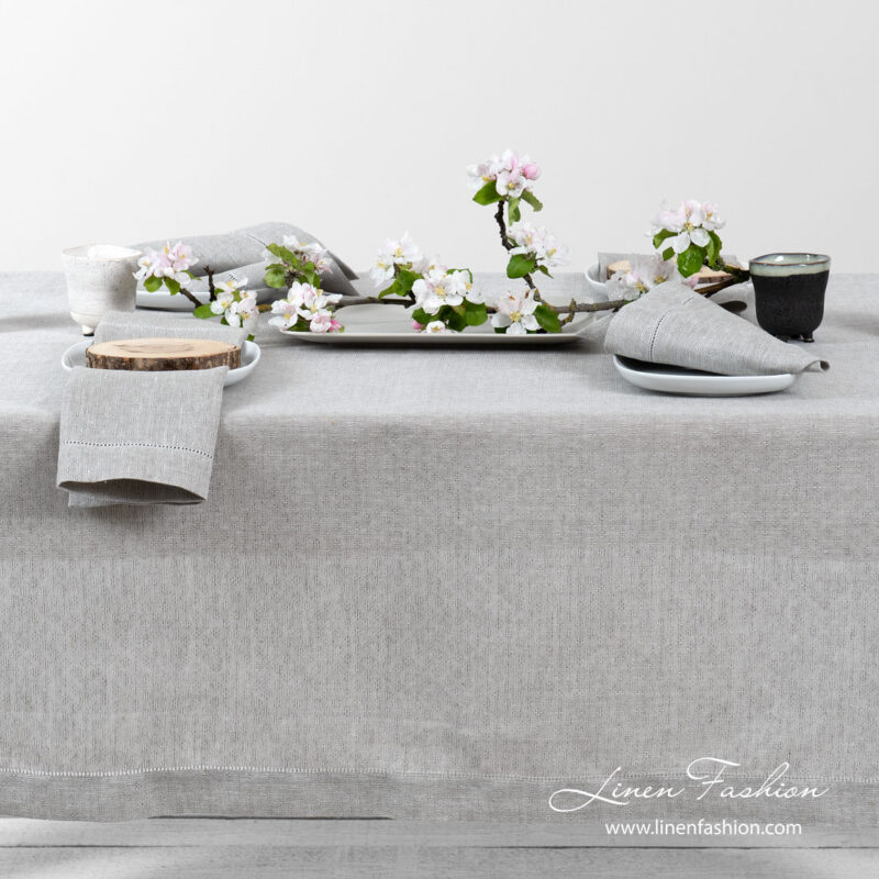 Light grey pure linen tablecloth in a small openwork pattern, and decorated with a row of hemstitch along its edges