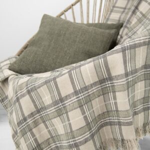 Beige checked linen cotton blanket draped on chair with green cushion
