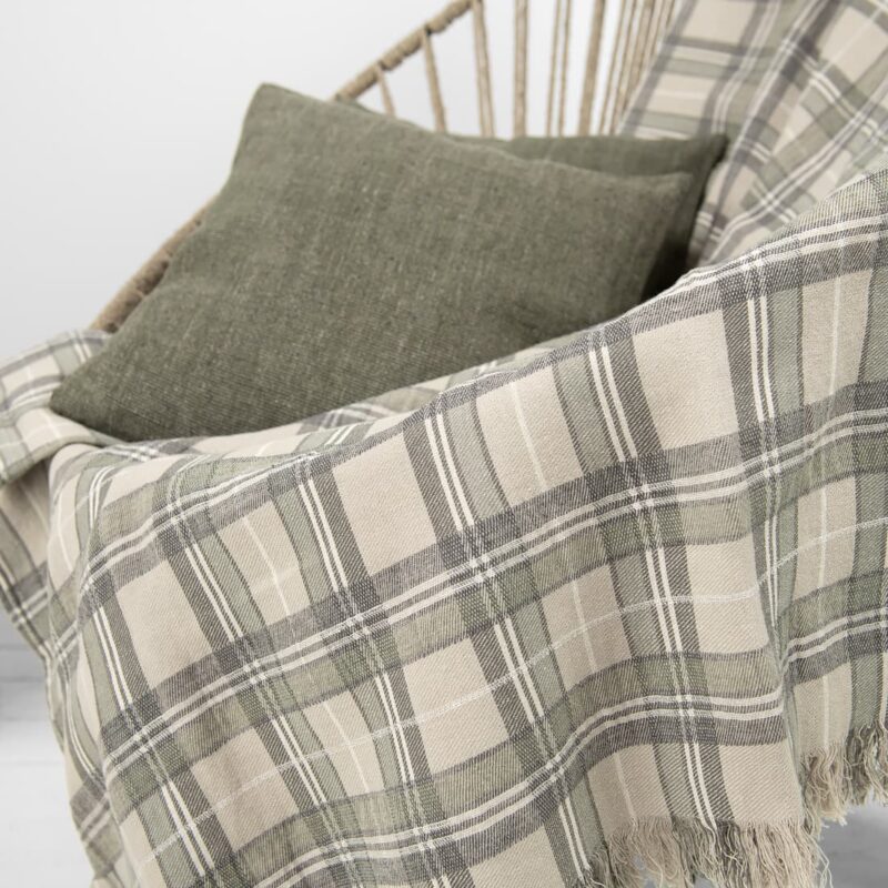 Beige checked linen cotton blanket draped on chair with green cushion