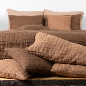 brown linen bedspread, with decorative cushions