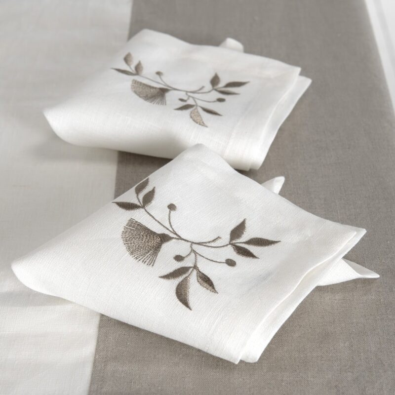 Off-white napkin with brownish floral stitching, 100% linen