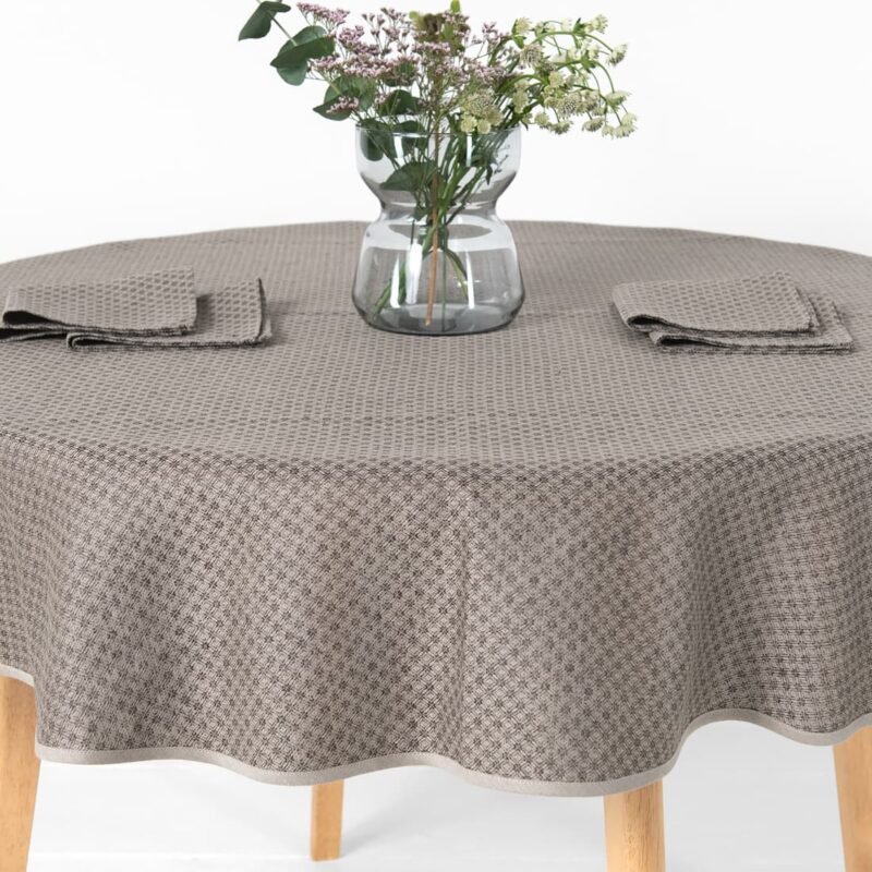 dark brown patterned linen-cotton tablecloth, with vase and napking