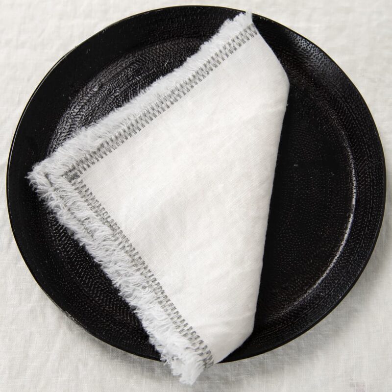 white linen napkin with decorative stitch.