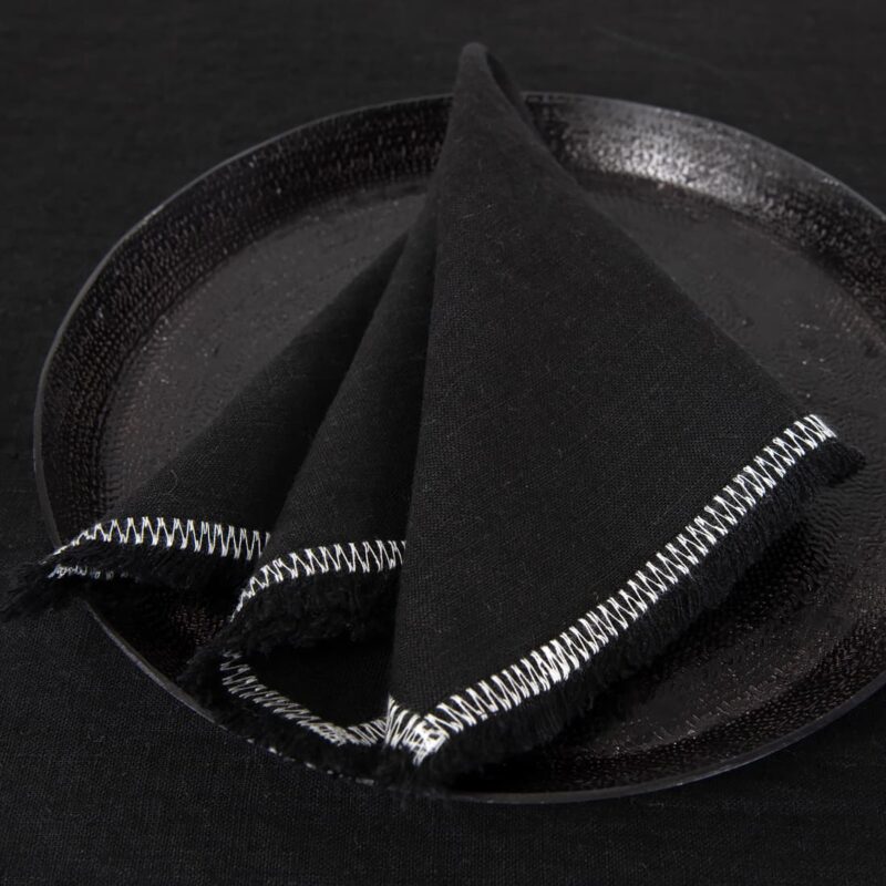 black linen napkin with decorative stitch.