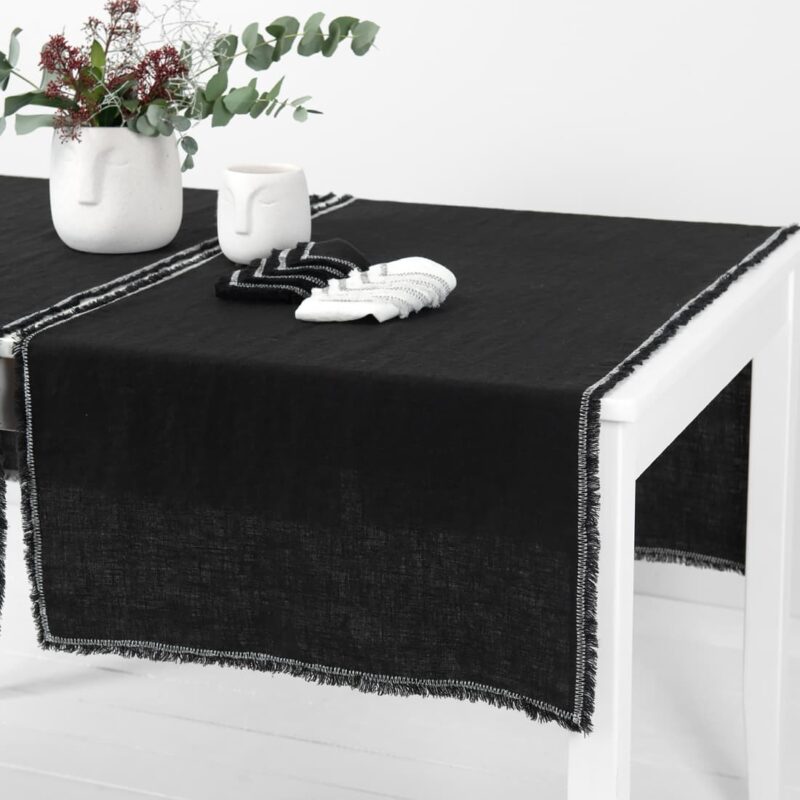 black linen runner with decorative stitch, washed.