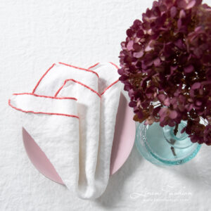 ARVO white napkin with rosy Babylock stitch border