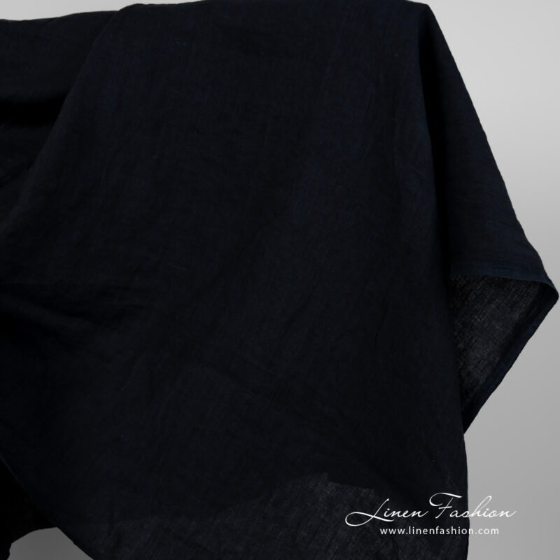 Wide washed linen fabric blueish black colour close edge view
