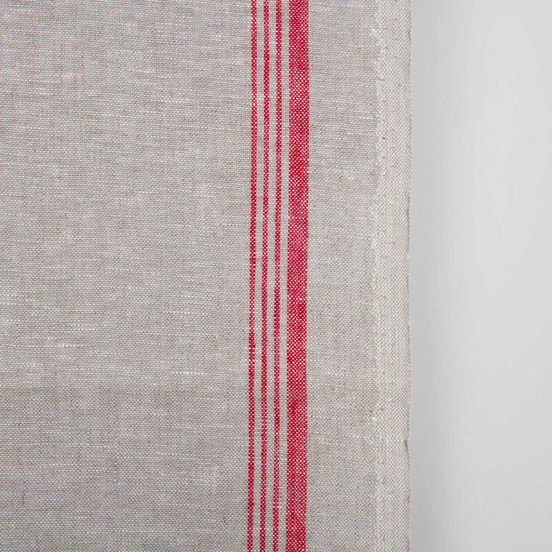 Narrow linen towel fabric in beige, with red stripes on one edge