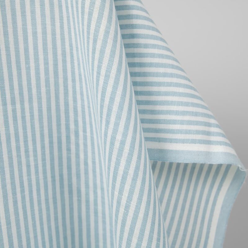 Wide linen cotton fabric in white and light turquoise stripes edge