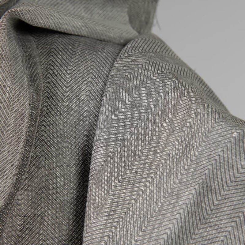 Linen fabric greyish brown in herringbone pattern close up detail